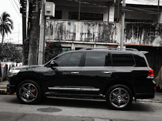 A sleek black SUV freshly detailed, parked on a sunny Palm Desert street.