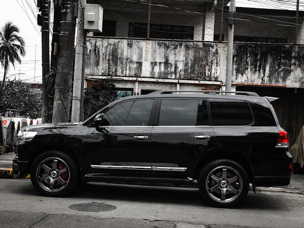 A sleek black SUV freshly detailed, parked on a sunny Palm Desert street.