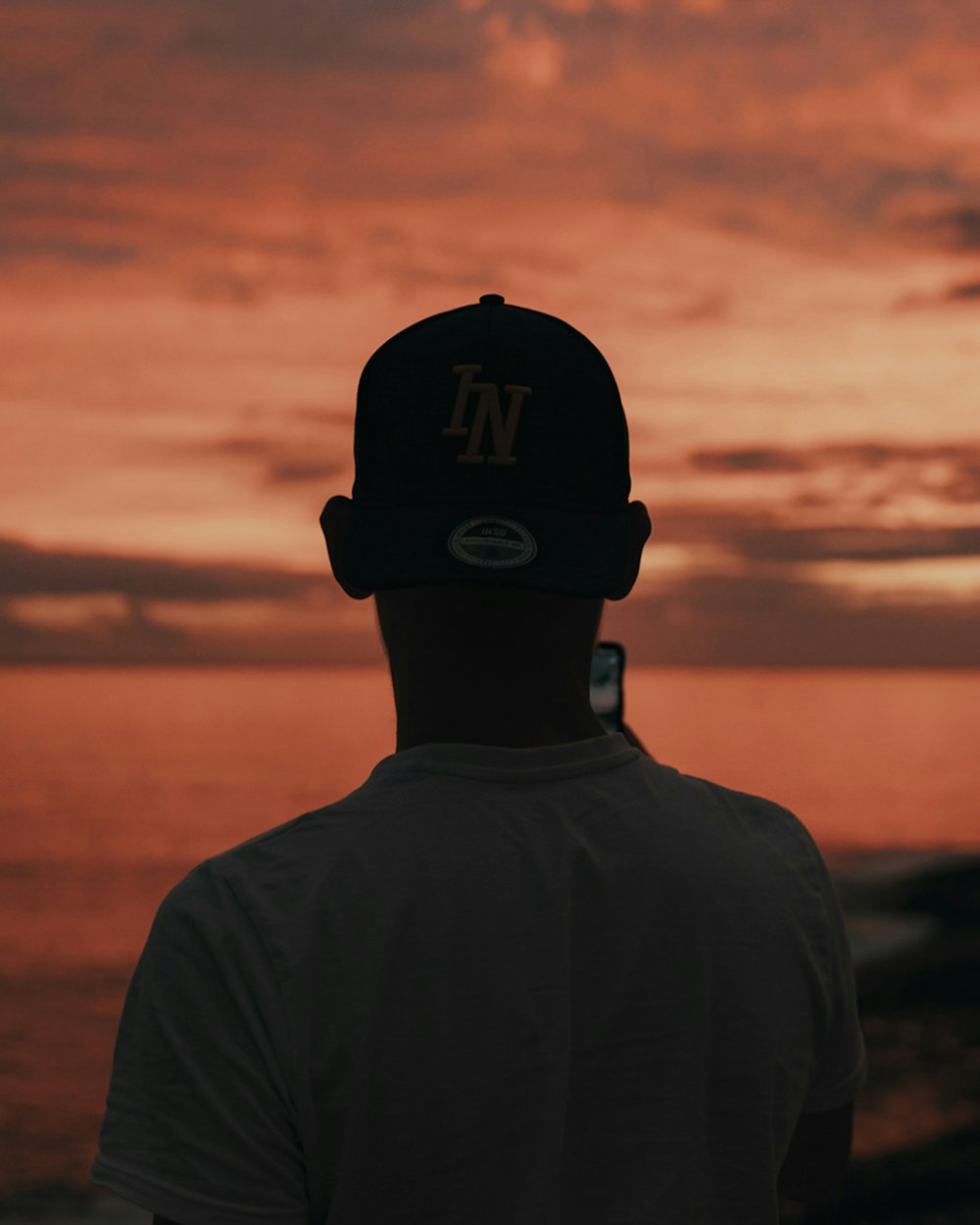 silhouette of man wearing black cap and black jacket