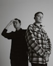 man in plaid dress shirt standing beside man in black dress shirt