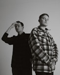 man in plaid dress shirt standing beside man in black dress shirt