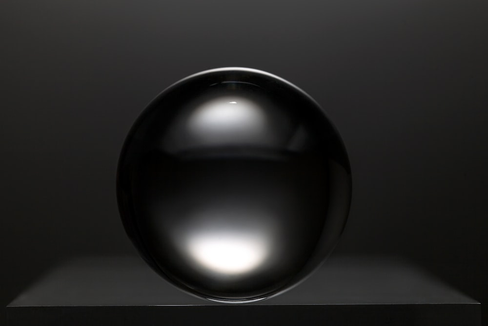 bola redonda preta na superfície branca