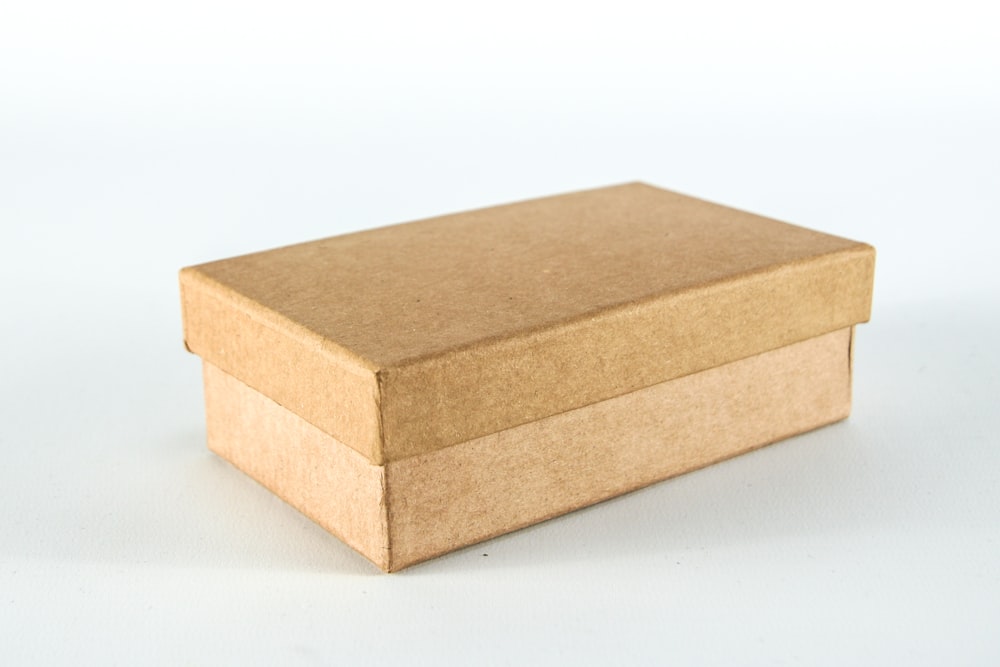 Boîte en carton brun sur surface blanche