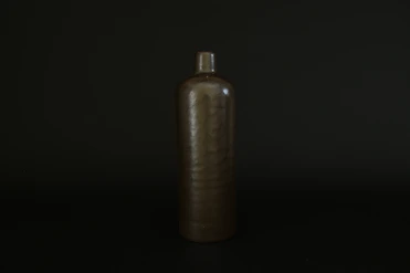 brown bottle on black surface