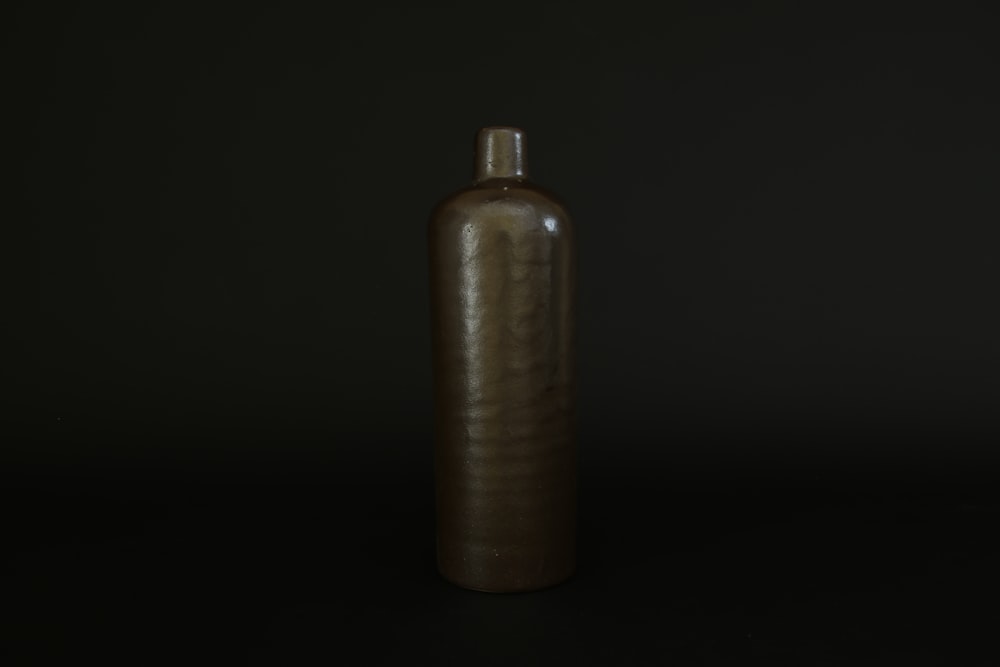 Botella marrón sobre superficie negra