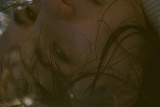 A close-up shot of a sunlit face with soft shadows highlighting delicate expressions.