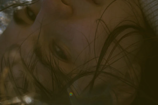 A close-up shot of a sunlit face with soft shadows highlighting delicate expressions.