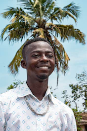 A warm portrait of Alberto García-Santiago smiling confidently in front of a luxury beachfront property in Punta Cana.