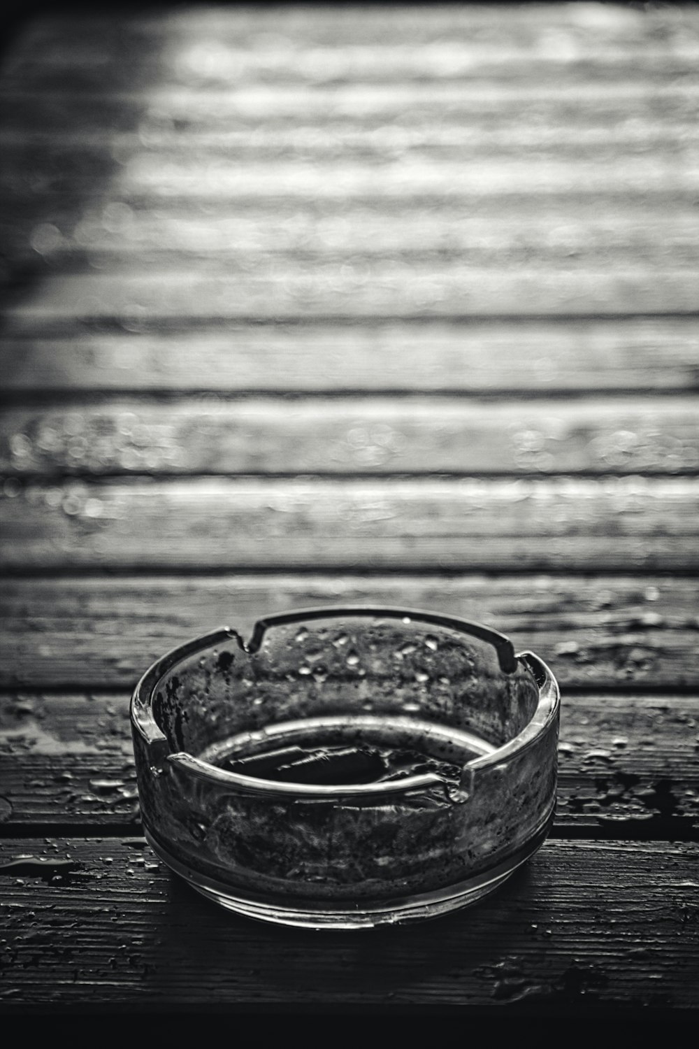 grayscale photo of clear drinking glass on wooden surface