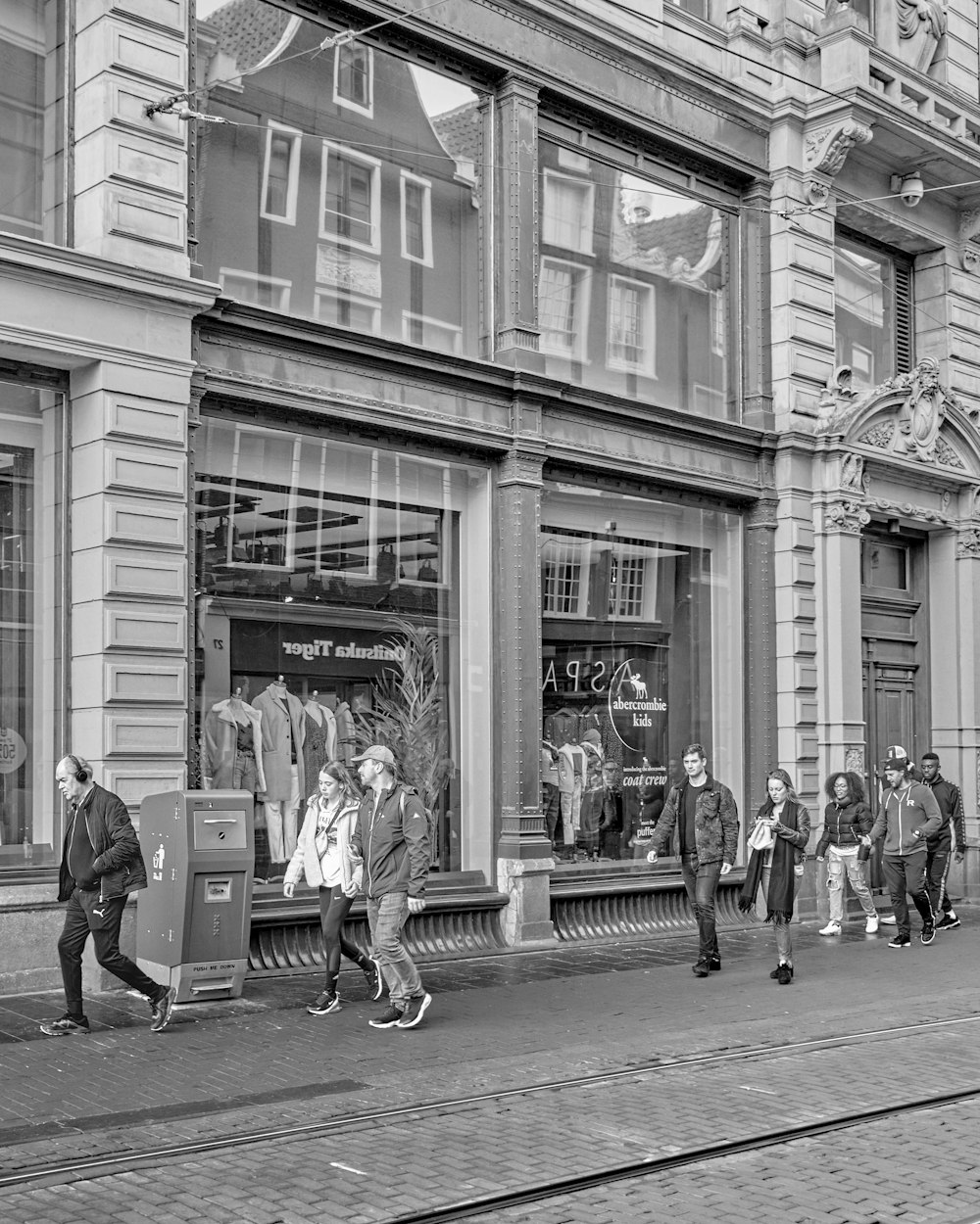 people walking on street in grayscale photography