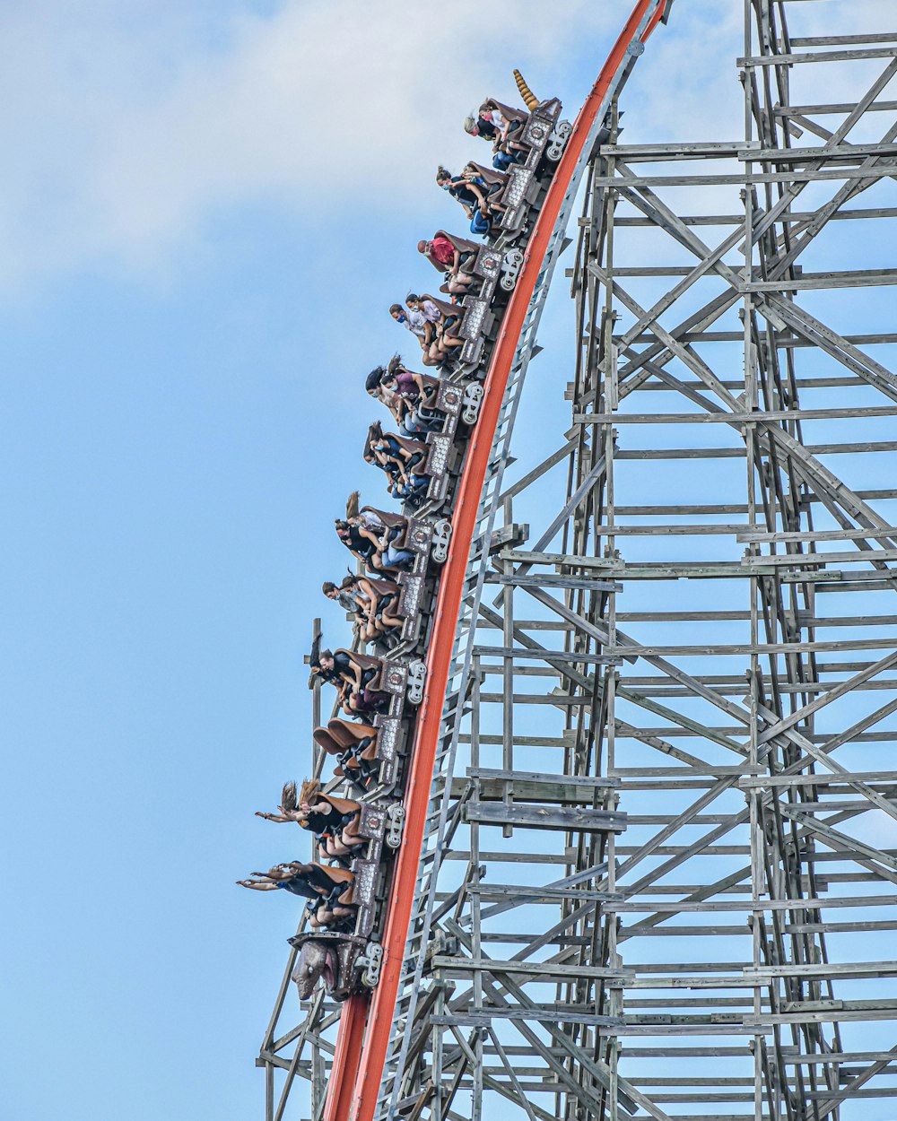 people riding roller coaster during daytime