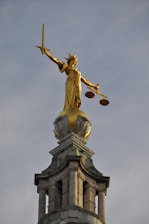 gold statue of man holding sword