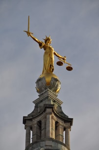 gold statue of man holding sword