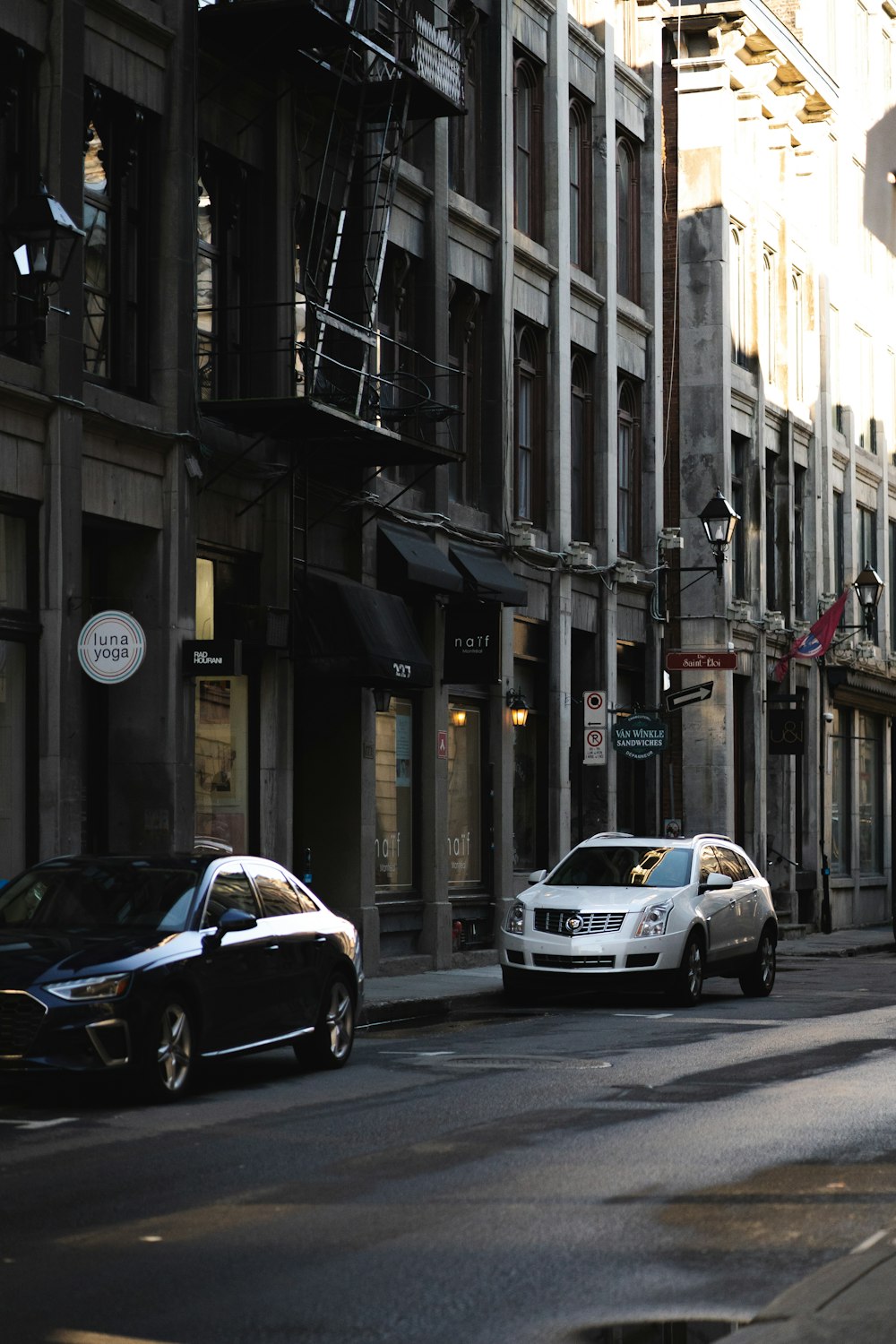 cars parked on side of the road in between buildings during daytime