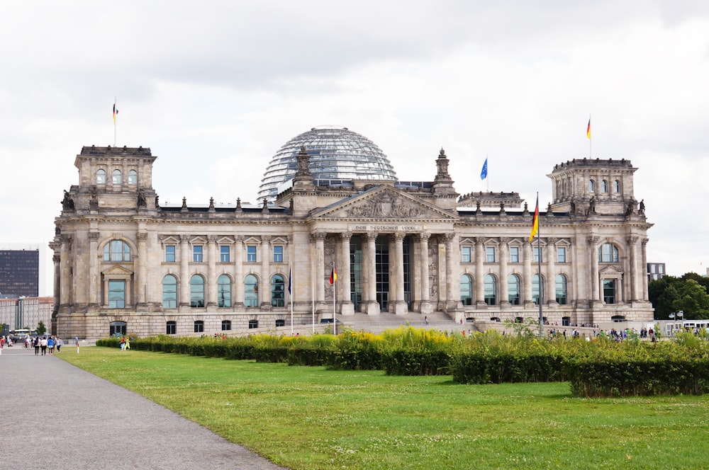 Weißes Betongebäude unter weißem Himmel tagsüber