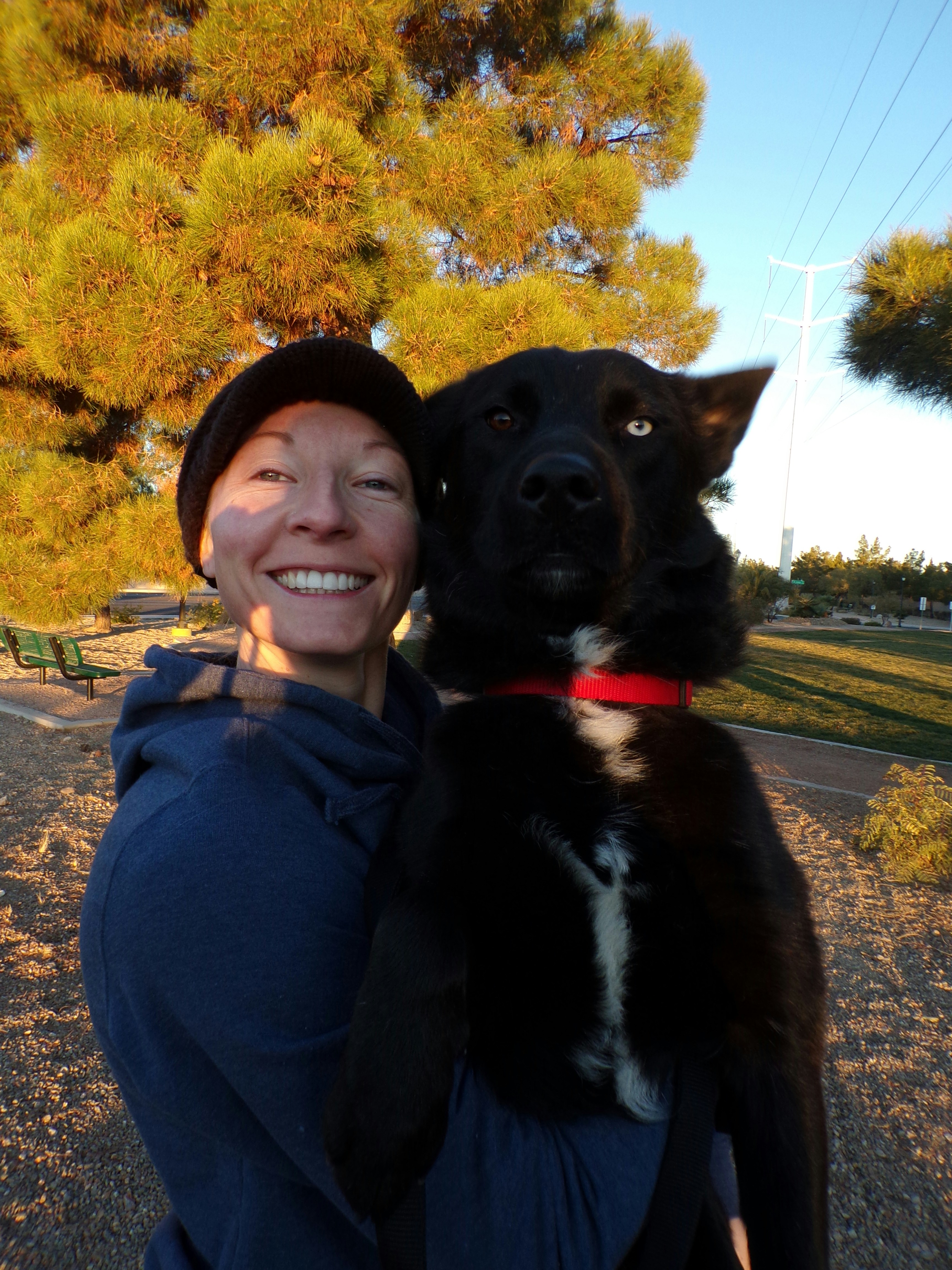 A cozy hoodie with a custom pet print, worn by a smiling pet owner outdoors.