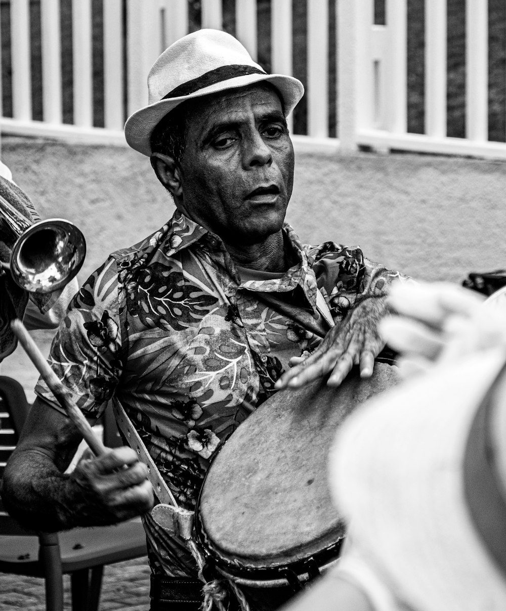 man playing musical instrument in grayscale photography