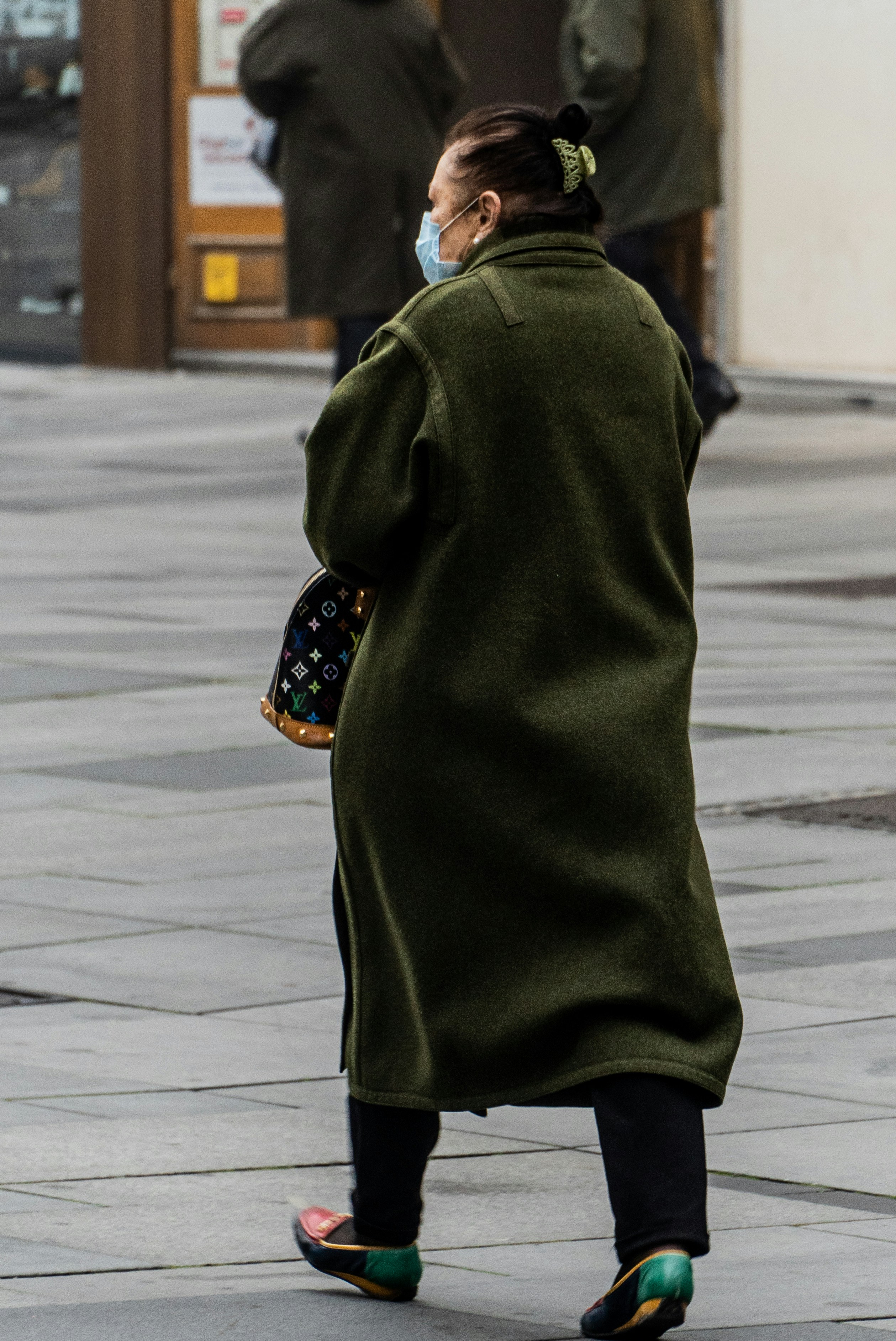 Woman wearing puffer jacket, chunky scarf, and jeans