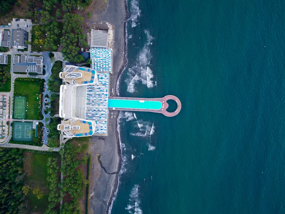 aerial view of white and blue building near body of water during daytime