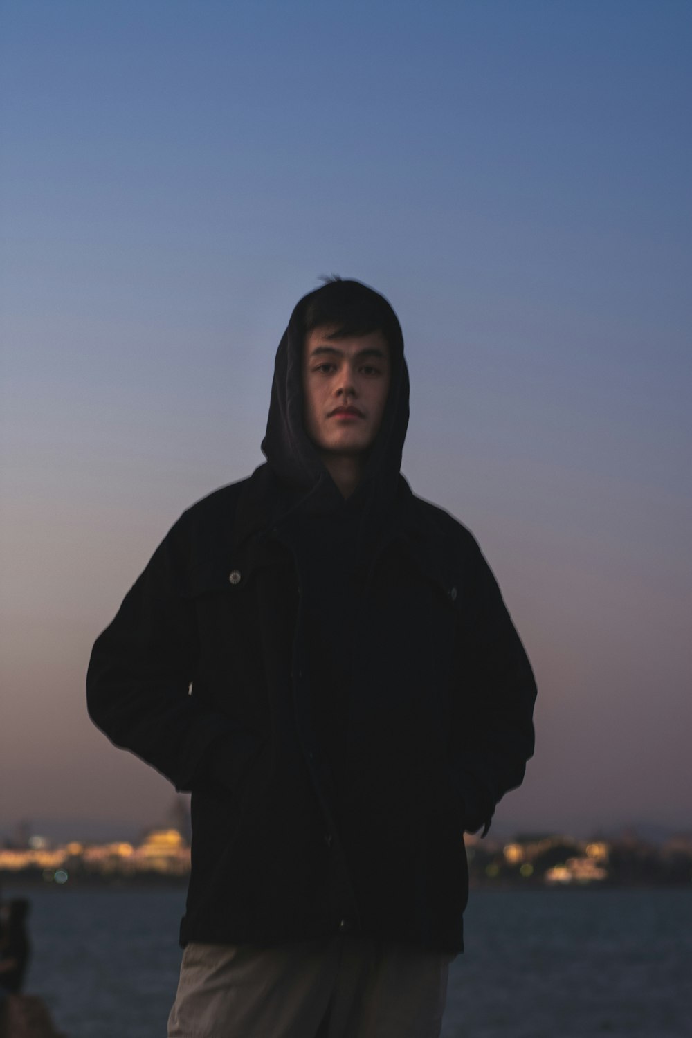 woman in black hoodie standing on field during daytime