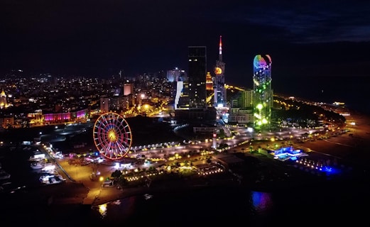 ferris wheel near city buildings during night time