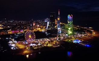 ferris wheel near city buildings during night time