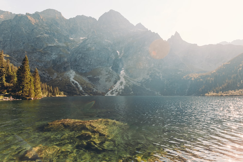 body of water near mountain during daytime