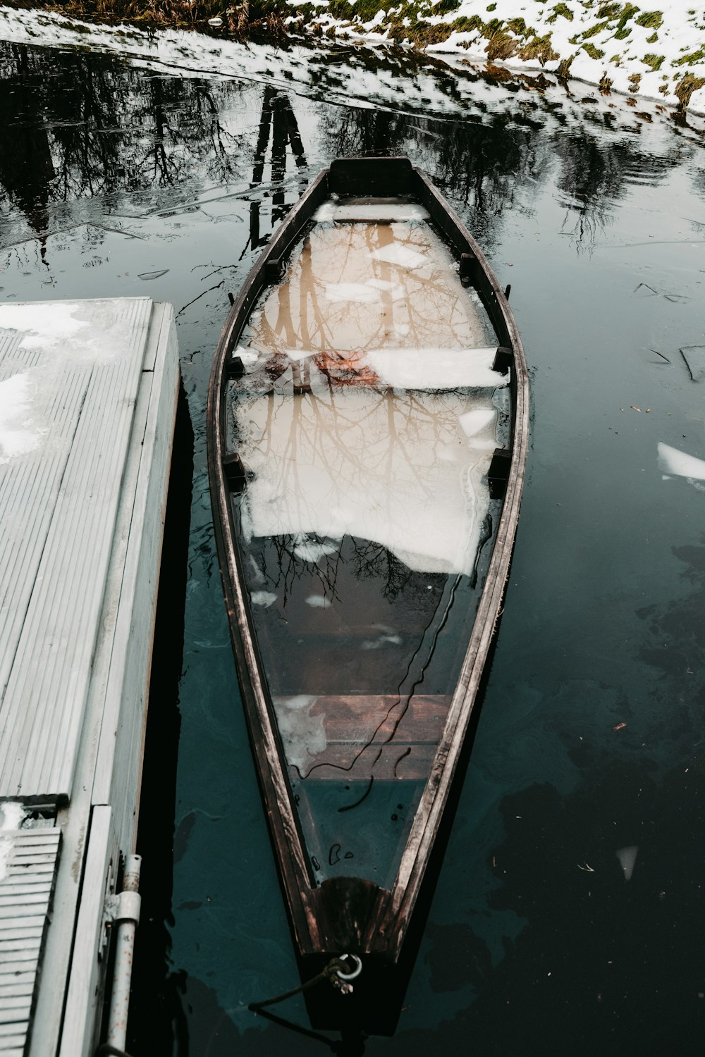 barca di legno marrone sullo specchio d'acqua durante il giorno