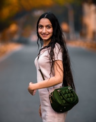 woman in white long sleeve shirt holding green sling bag