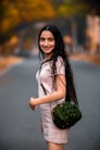 woman in white long sleeve shirt holding green sling bag