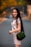 woman in white long sleeve shirt holding green sling bag