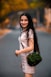 woman in white long sleeve shirt holding green sling bag