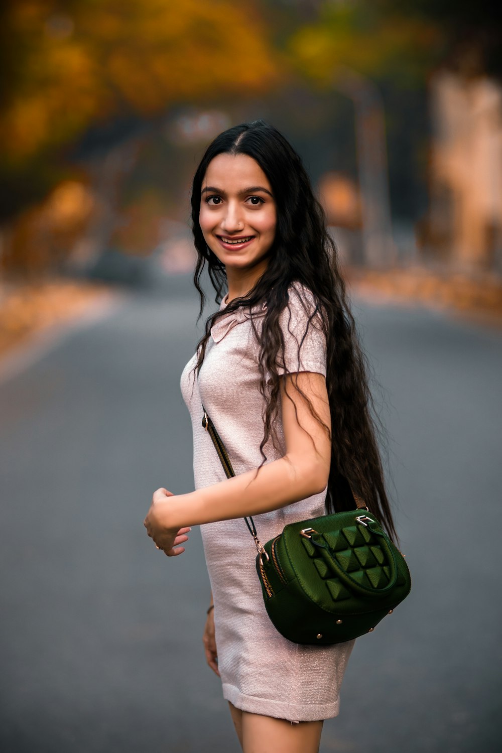 woman in white long sleeve shirt holding green sling bag