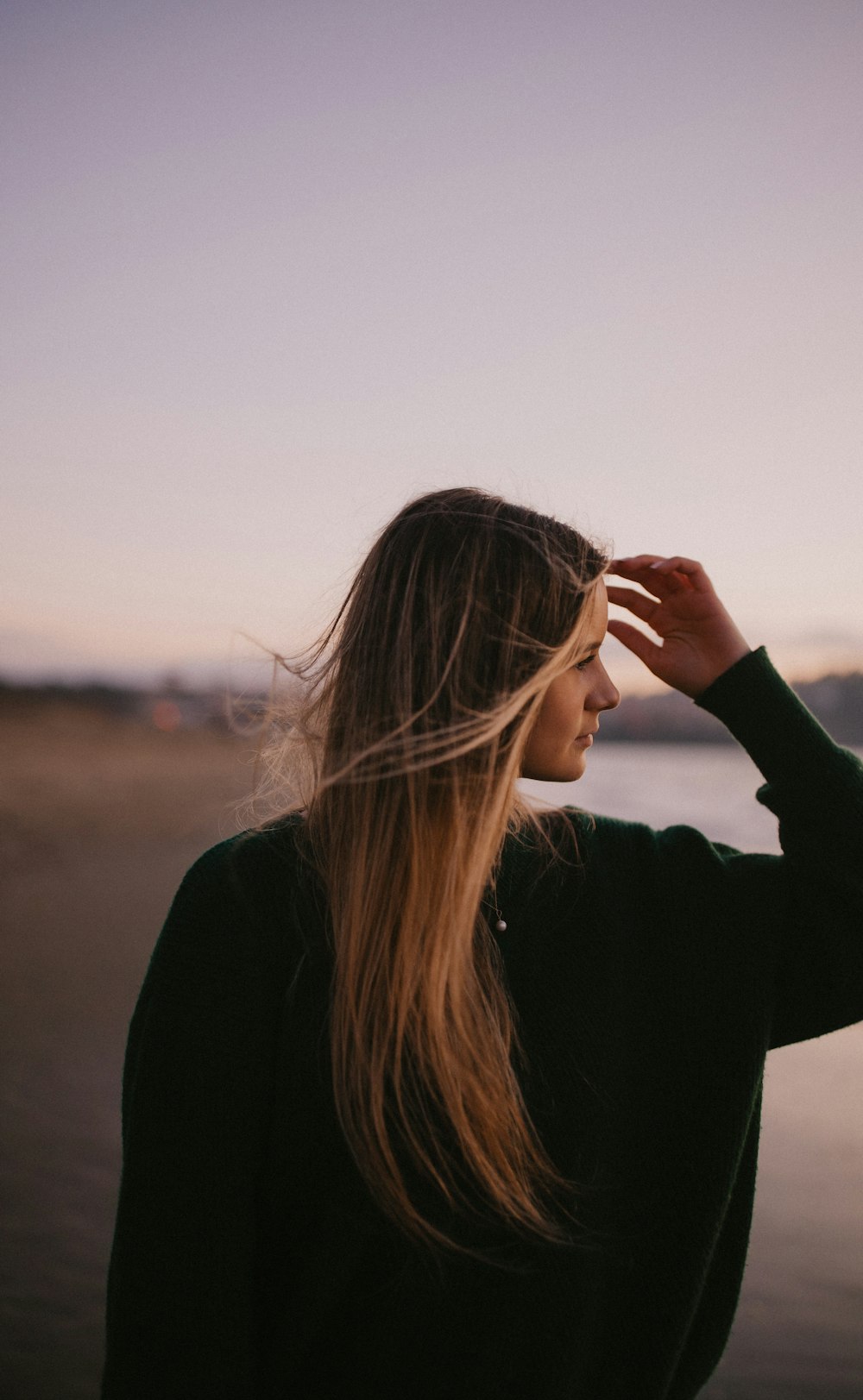 woman in black long sleeve shirt covering her face with her hair