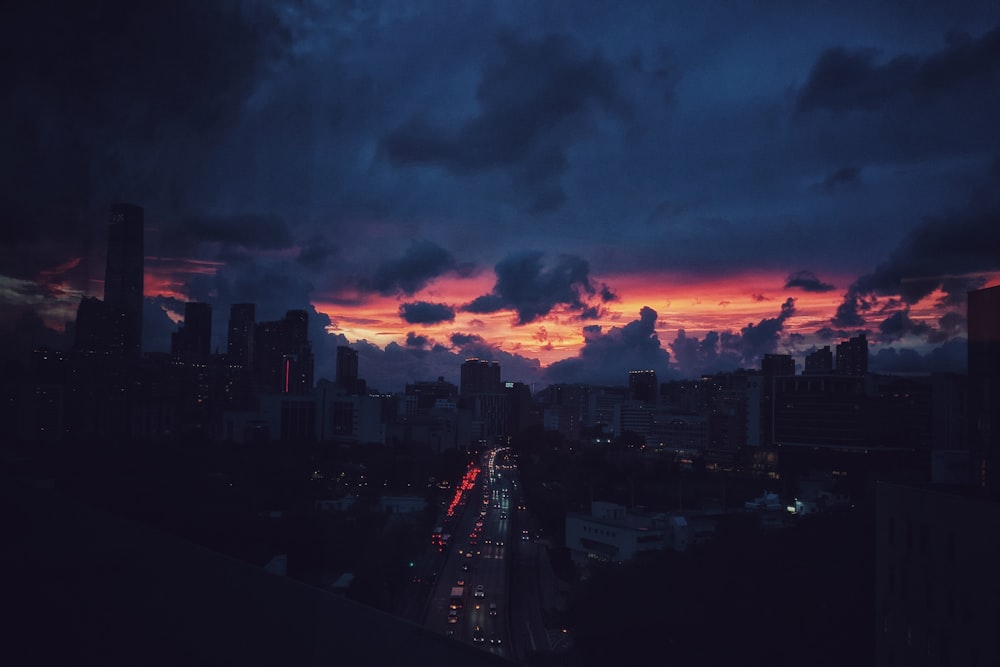 city skyline under cloudy sky during sunset