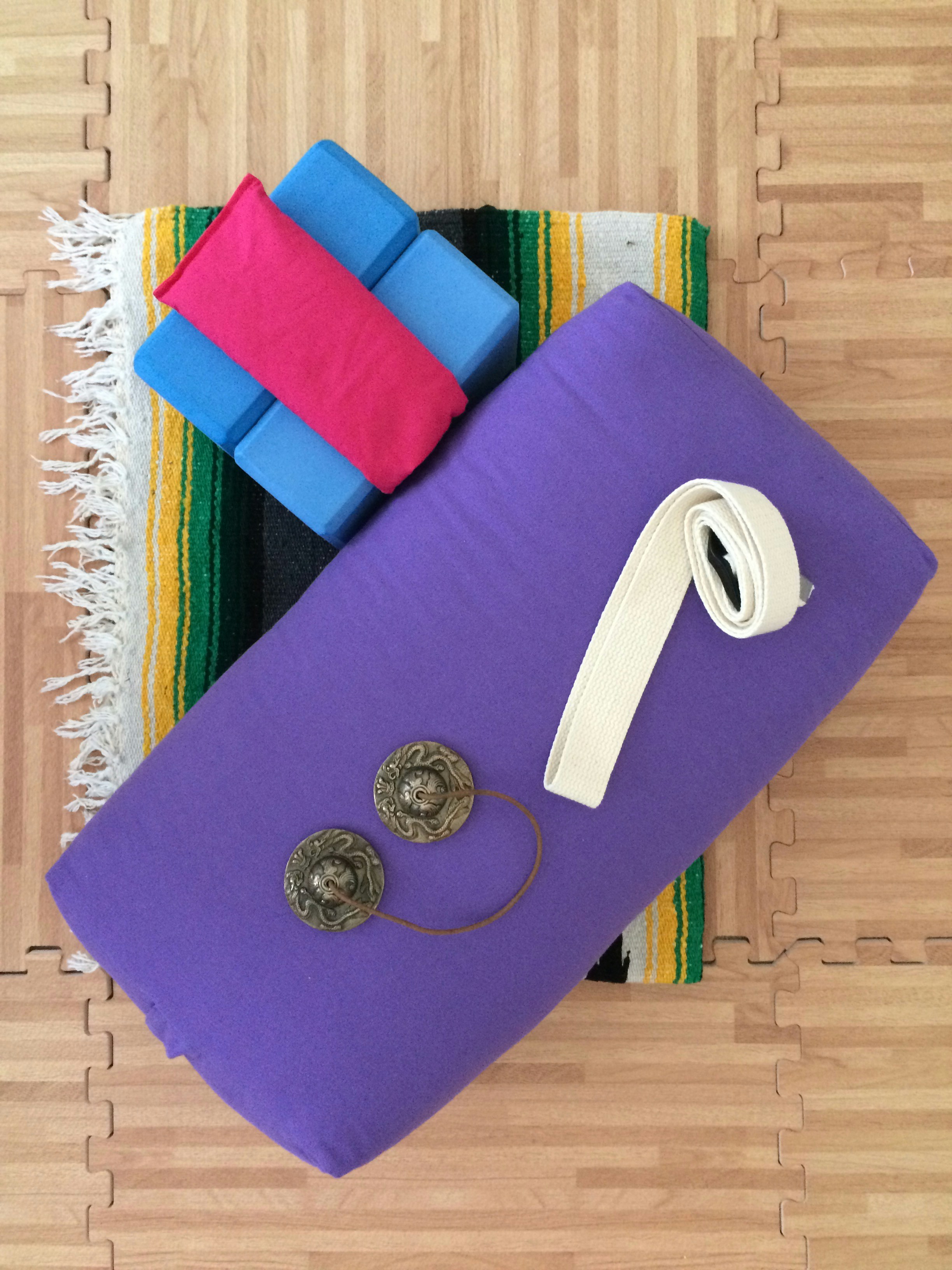 Pilates ring and yoga mat arranged on a clean wooden floor
