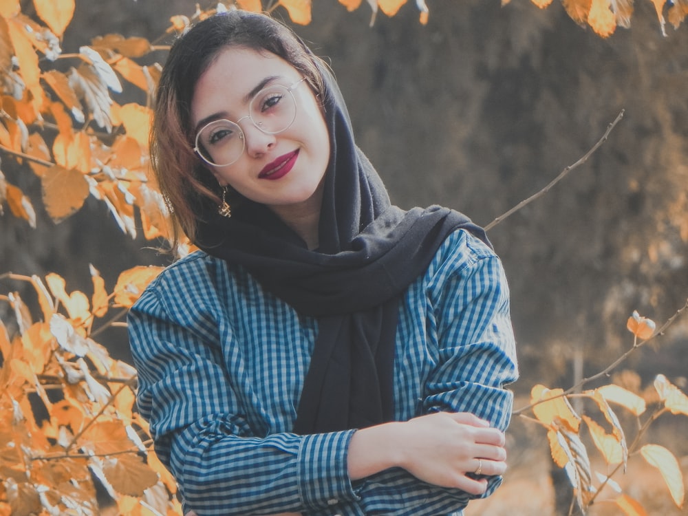 mulher na camisa azul e branca de manga comprida sorrindo