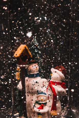 A playful Christmas card showing cheerful snowmen wearing colorful scarves and hats.