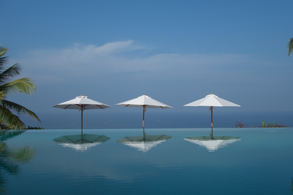 white umbrella on body of water during daytime