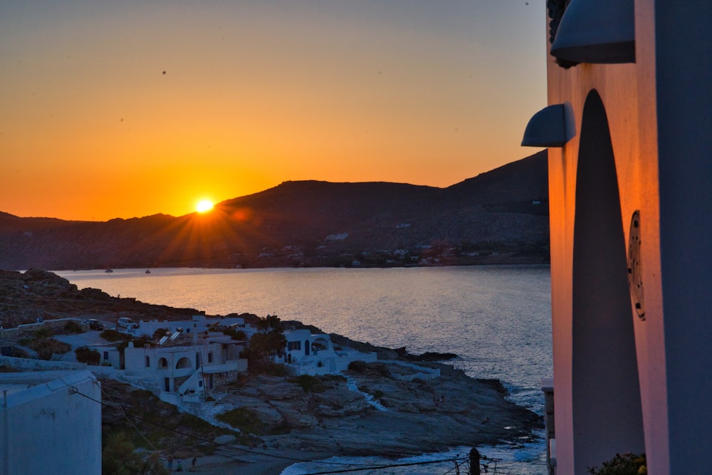 white and brown houses near body of water during sunset