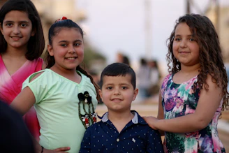 girl in blue and pink floral dress beside boy in green crew neck t-shirt