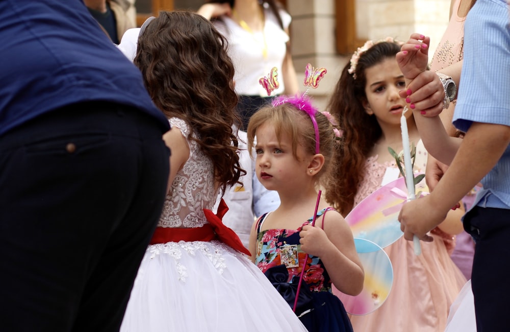 woman in white dress holding girl in white dress