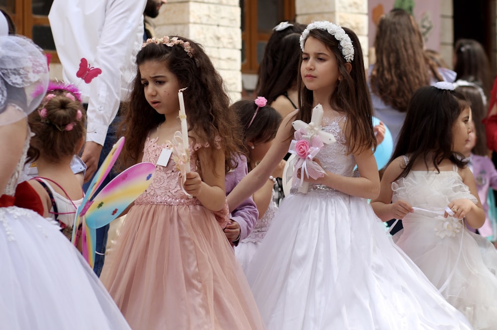 2 women in white dress holding hands