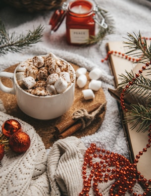 A festive table setting with a cup of cocoa and holiday crafts.