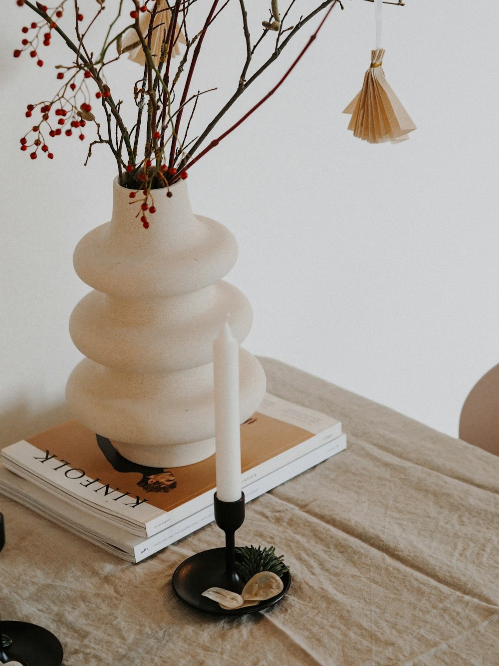Vase en céramique blanche sur livre blanc