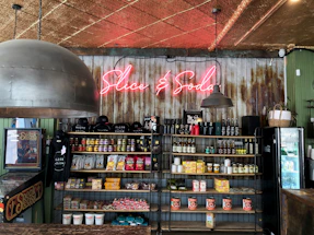 A cozy corner of Slice Oasis with a welcoming staff member ready to assist guests.