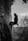 grayscale photo of man climbing on rock
