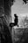 grayscale photo of man climbing on rock