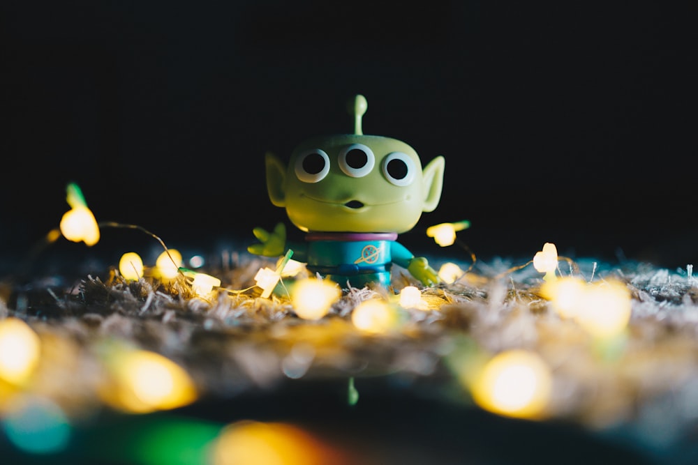 yellow and blue owl figurine on dried leaves