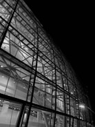 Side-by-side view of a detailed AutoCAD 3D render and the finished aluminum facade installed on a modern building.